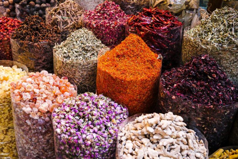 Colorful spices and dried flowers on display at Dubai's bustling spice souk market.
