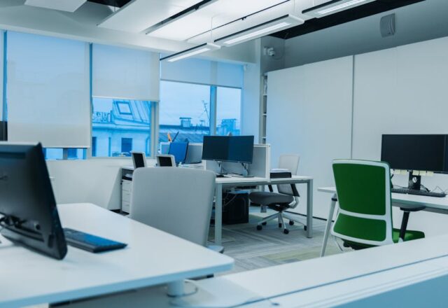 Bright and modern office environment with computer workstations and large windows.