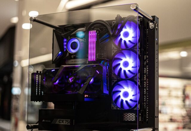 Modern gaming computer with vibrant LED fans and sleek glass design, showcasing high-performance components.