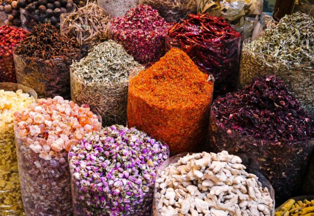 Colorful spices and dried flowers on display at Dubai's bustling spice souk market.